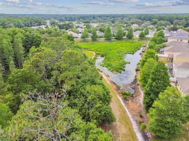 drone / aerial view featuring a wooded view and a residential view