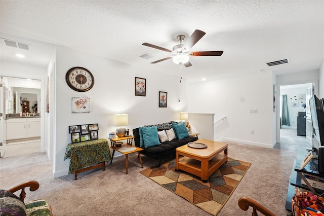 carpeted living room with a textured ceiling and ceiling fan