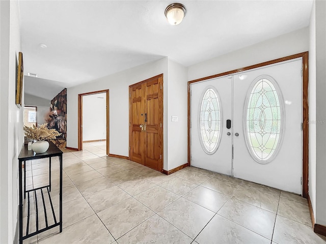 foyer with lofted ceiling and light tile patterned flooring