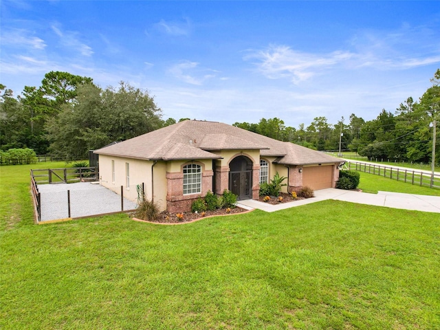 mediterranean / spanish-style home with a garage and a front lawn