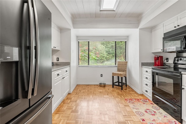 kitchen with white cabinetry, black appliances, and baseboards