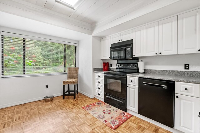 kitchen with black appliances, white cabinets, and light parquet floors