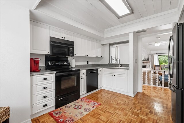 kitchen with light parquet floors, black appliances, sink, white cabinetry, and ceiling fan