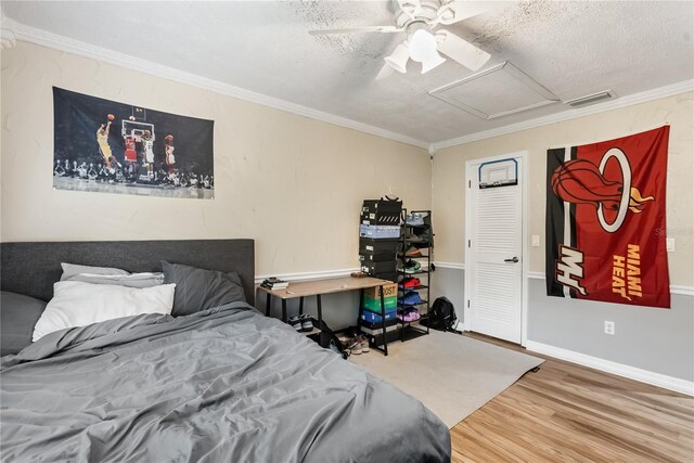 bedroom featuring hardwood / wood-style floors, ceiling fan, crown molding, and a textured ceiling