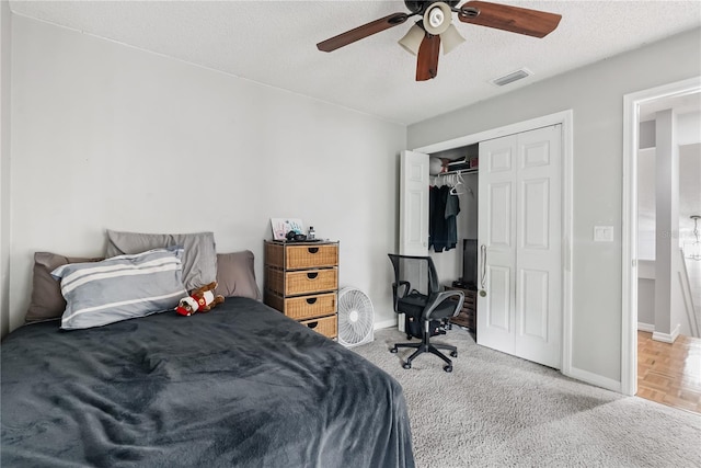 bedroom with visible vents, baseboards, a closet, a textured ceiling, and a ceiling fan