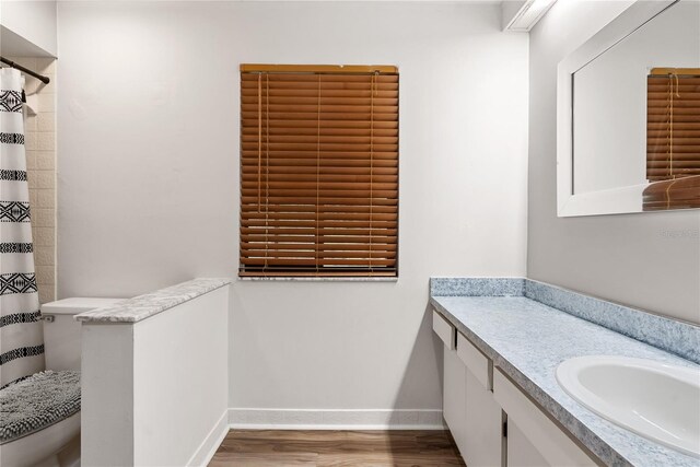 bathroom featuring a shower with curtain, toilet, hardwood / wood-style flooring, and vanity