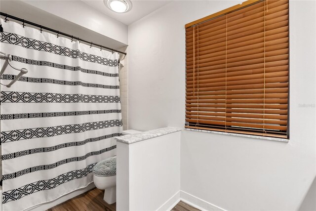 bathroom featuring curtained shower and wood-type flooring