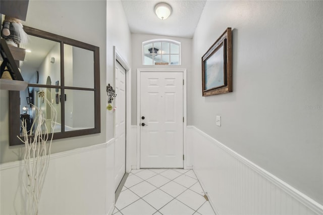 tiled entrance foyer with lofted ceiling and a textured ceiling