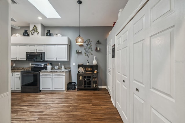 kitchen featuring a skylight, stainless steel appliances, white cabinetry, dark wood-type flooring, and pendant lighting