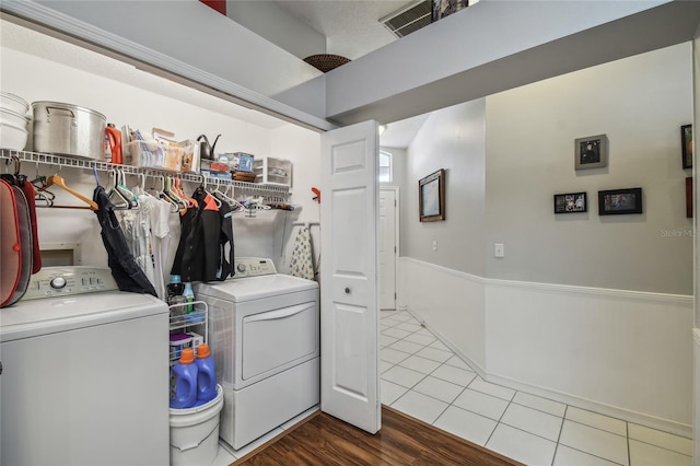 laundry room with separate washer and dryer and hardwood / wood-style flooring