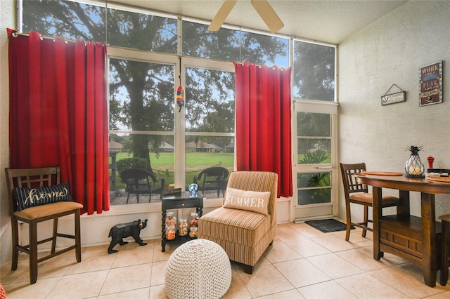 sitting room featuring a wealth of natural light, light tile patterned floors, and ceiling fan