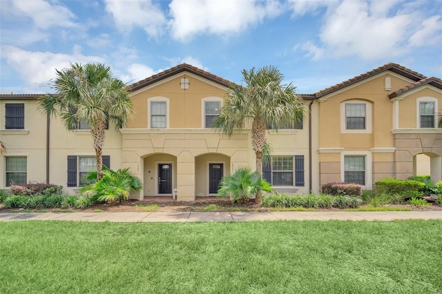 mediterranean / spanish home with a front lawn