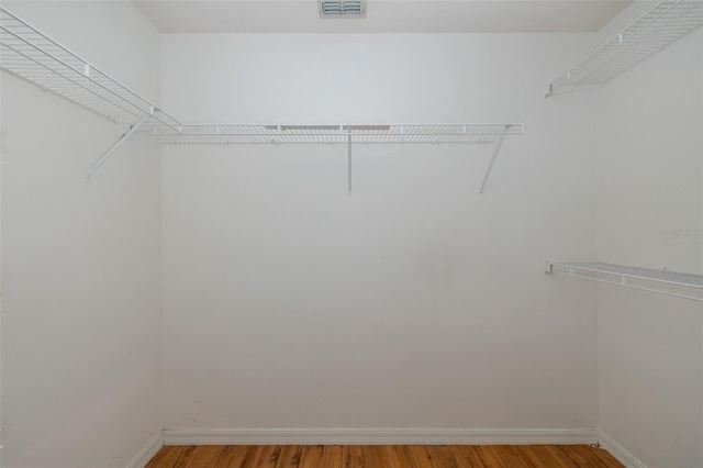 spacious closet featuring visible vents and wood finished floors