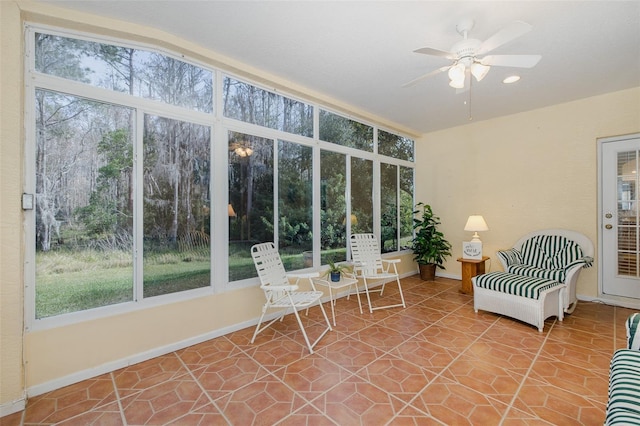 unfurnished sunroom with ceiling fan