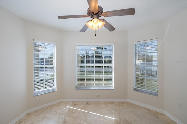 unfurnished room with ceiling fan and a wealth of natural light