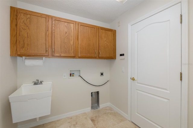 laundry room with a sink, cabinet space, baseboards, hookup for an electric dryer, and hookup for a washing machine