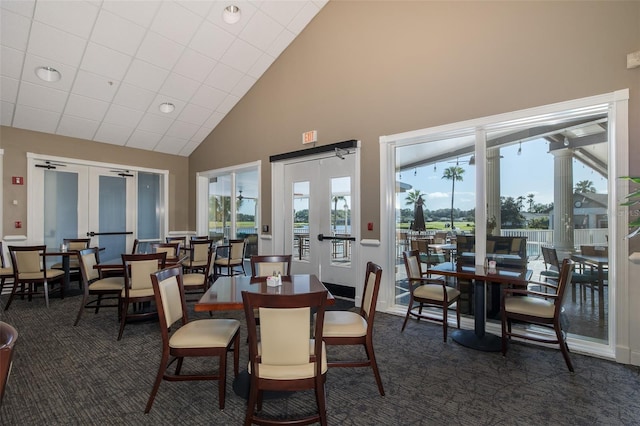 dining area featuring a wealth of natural light, dark carpet, and french doors