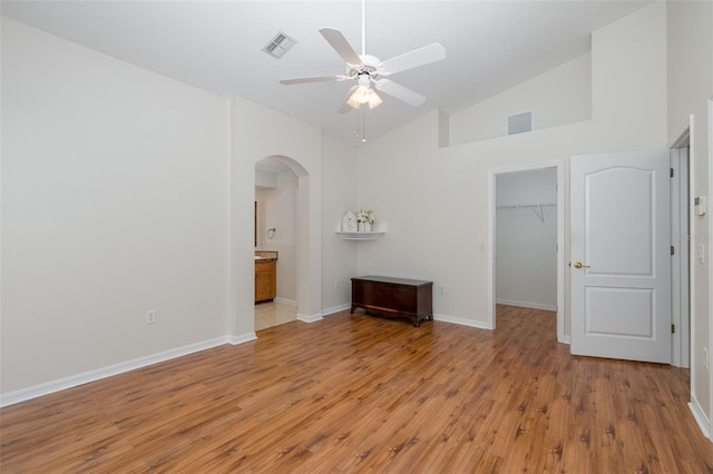 spare room featuring ceiling fan, high vaulted ceiling, and light wood-type flooring