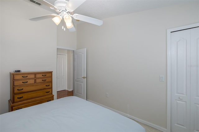 bedroom featuring a closet, visible vents, baseboards, and a ceiling fan