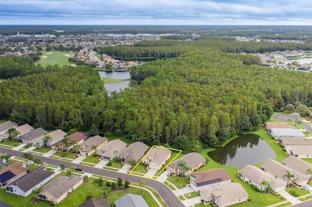 birds eye view of property featuring a forest view, a water view, and a residential view