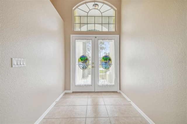 doorway with light tile patterned floors and french doors