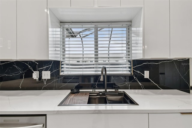 kitchen with white cabinetry, tasteful backsplash, and sink