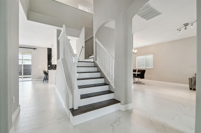 staircase featuring an inviting chandelier