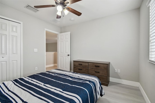 bedroom with ceiling fan, a closet, and light hardwood / wood-style flooring