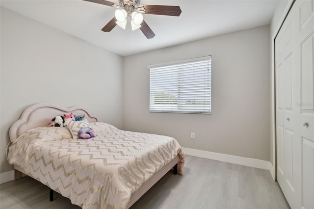 bedroom with ceiling fan, a closet, and light hardwood / wood-style flooring