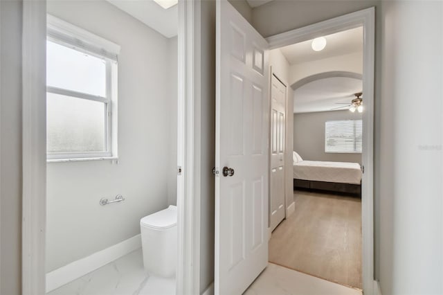 bathroom with ceiling fan and toilet