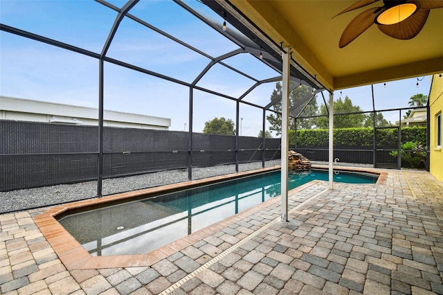 view of swimming pool with ceiling fan, a lanai, and a patio area