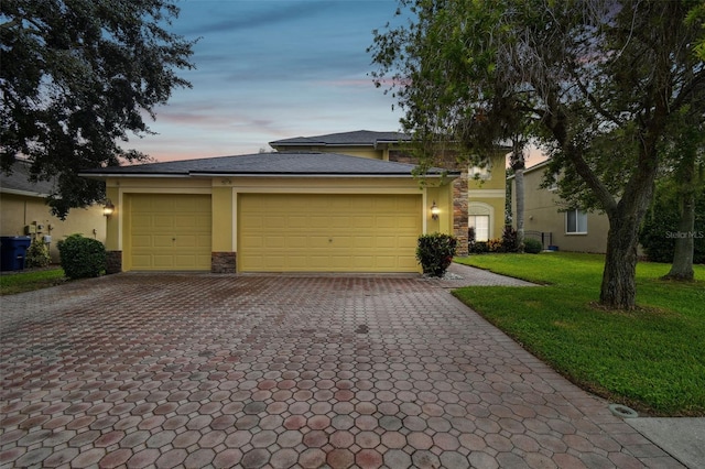 view of front of property featuring a yard and a garage