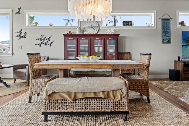 dining room with a healthy amount of sunlight, hardwood / wood-style floors, and a chandelier