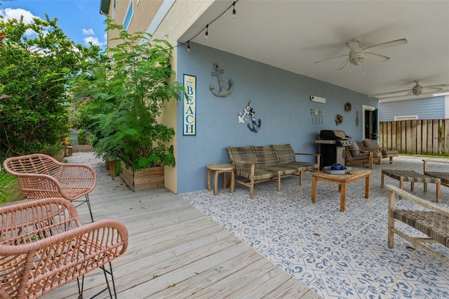 deck with ceiling fan, grilling area, and an outdoor living space