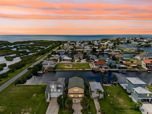 aerial view at dusk featuring a water view