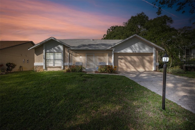 ranch-style home featuring a garage and a lawn