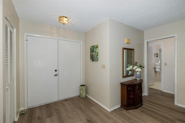 foyer entrance with a textured ceiling and hardwood / wood-style flooring