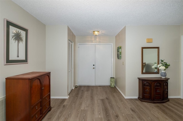 foyer featuring light hardwood / wood-style floors and a textured ceiling