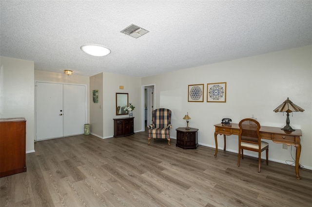 interior space with a textured ceiling and light wood-type flooring