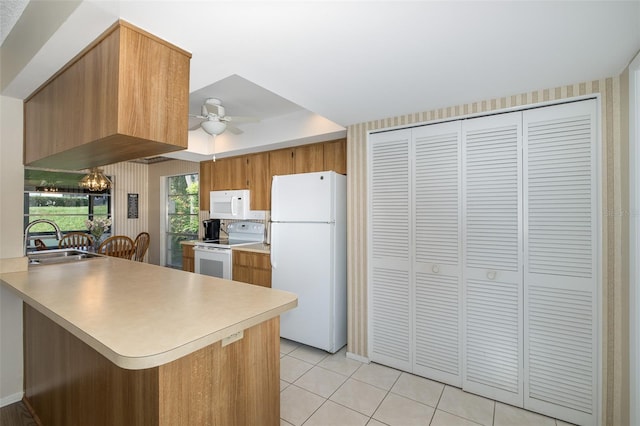 kitchen featuring kitchen peninsula, light tile patterned flooring, ceiling fan with notable chandelier, sink, and white appliances