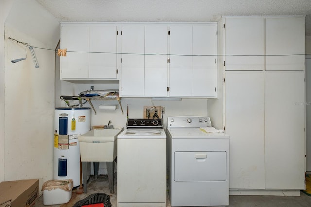 laundry area with a textured ceiling, electric water heater, cabinets, and washer and clothes dryer