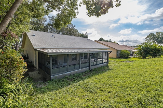 back of house with a yard and a sunroom