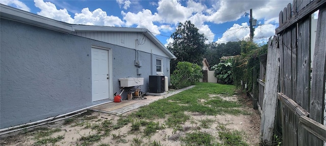 view of yard with central AC and sink