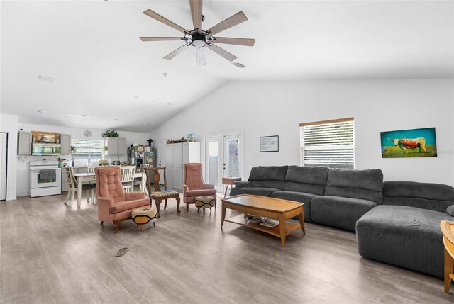 living room with ceiling fan, wood-type flooring, and a healthy amount of sunlight