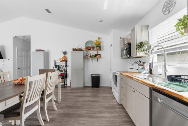 kitchen featuring light hardwood / wood-style flooring, wood counters, stainless steel appliances, sink, and lofted ceiling