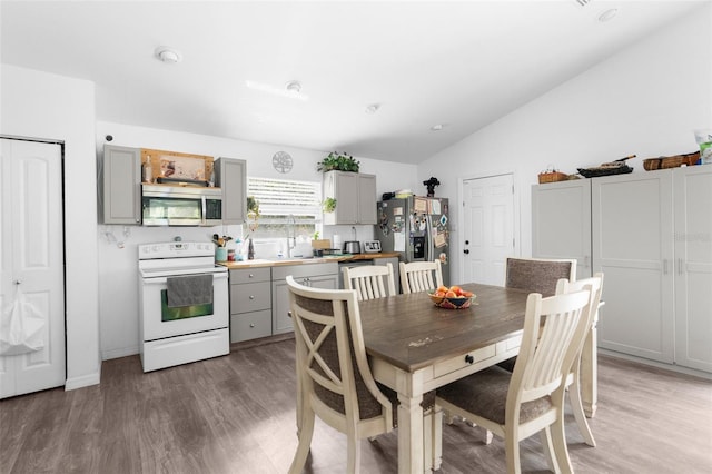 dining room featuring hardwood / wood-style floors and vaulted ceiling