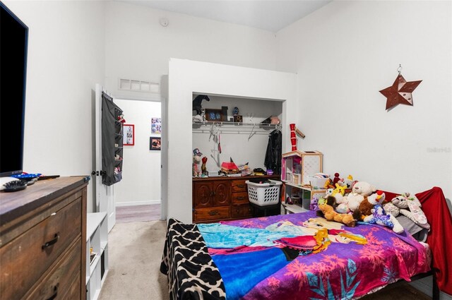 bedroom featuring a closet and light carpet