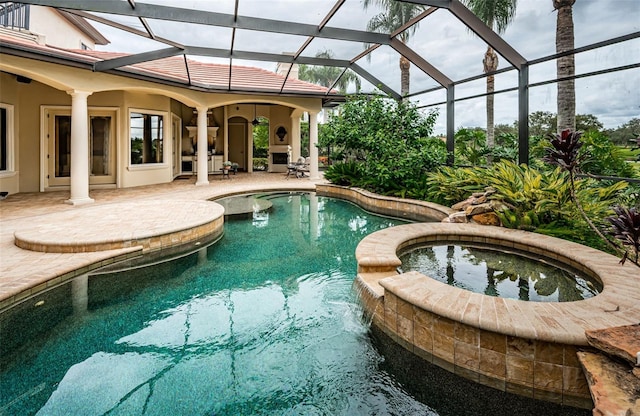 view of pool with a lanai, a patio, and an in ground hot tub