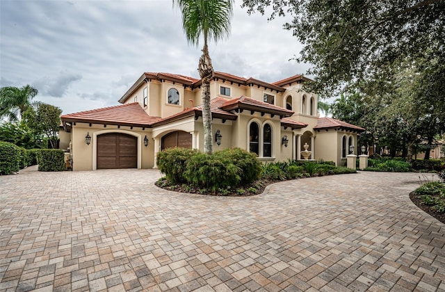 9943 Milano Dr, Trinity, FL 34655 - mediterranean / spanish-style home with a tiled roof, a garage, decorative driveway, and stucco siding