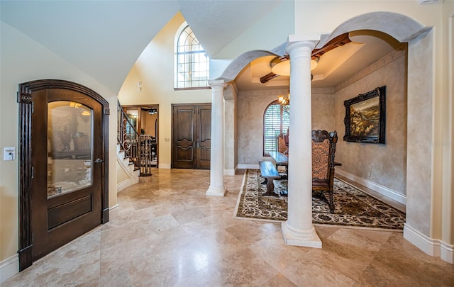 entryway featuring an inviting chandelier and decorative columns